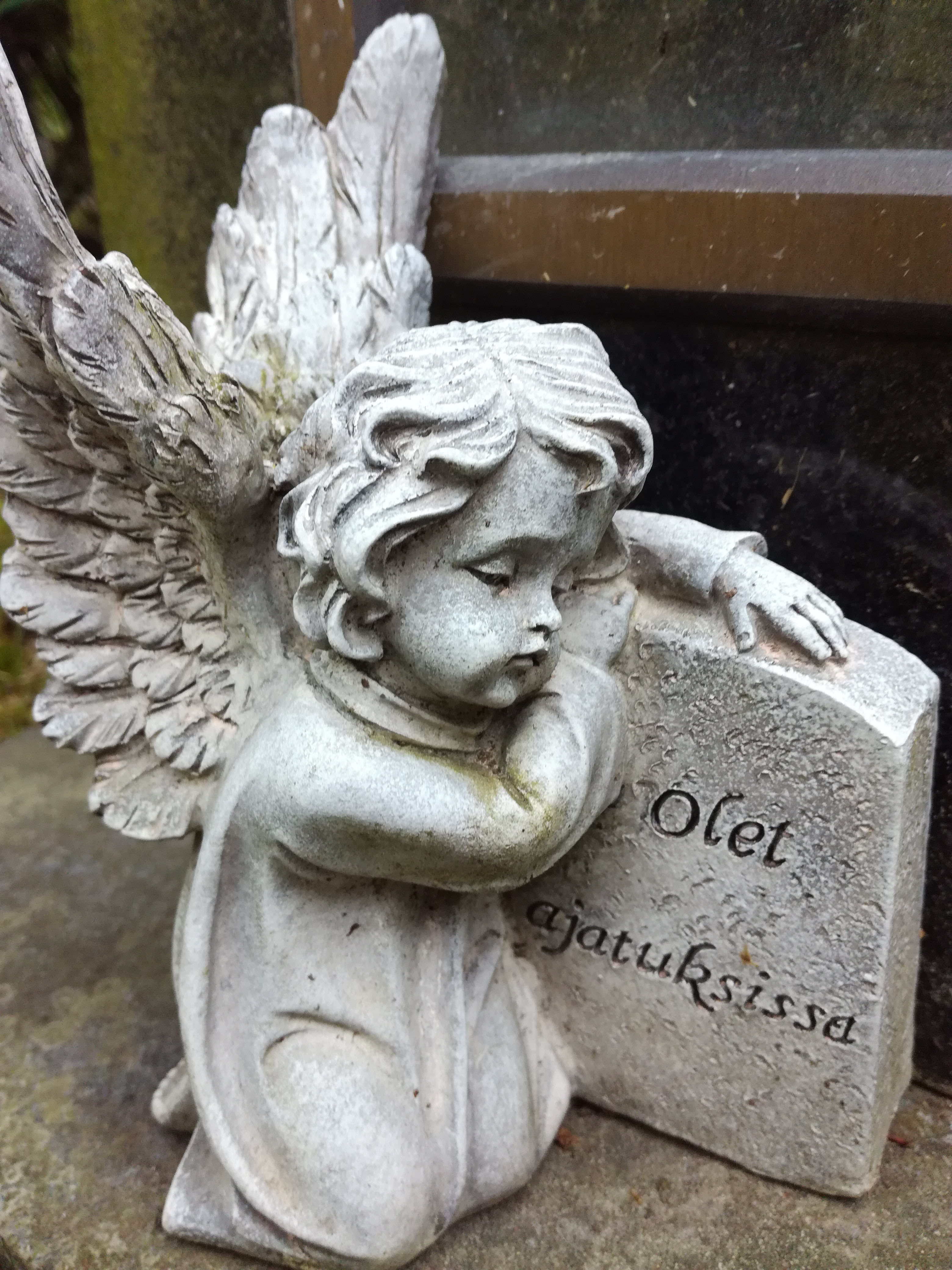 Patsas, jossa enkeli nojaa hautakiveen. Kivessä lukee Olet ajatuksissa.
